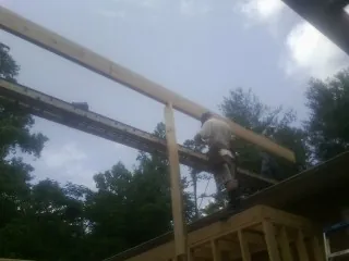 Carpenter setting a ridge beam over a new addition frame — Ice Dam Removal by Roofing Brothers in Castro Valley