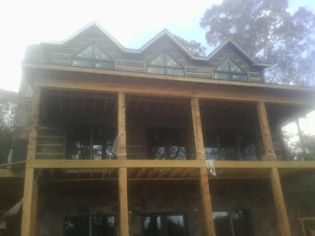 Dormers and porch framing on a large log home under construction — Roof Coating work by our crew in Castro Valley