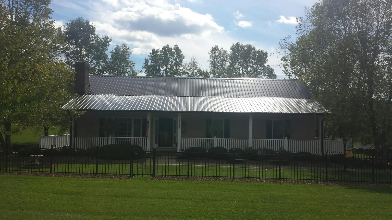 Gray metal roof on a brick ranch with a full width front porch — Gutter Guard Installation work by our crew in Castro Valley