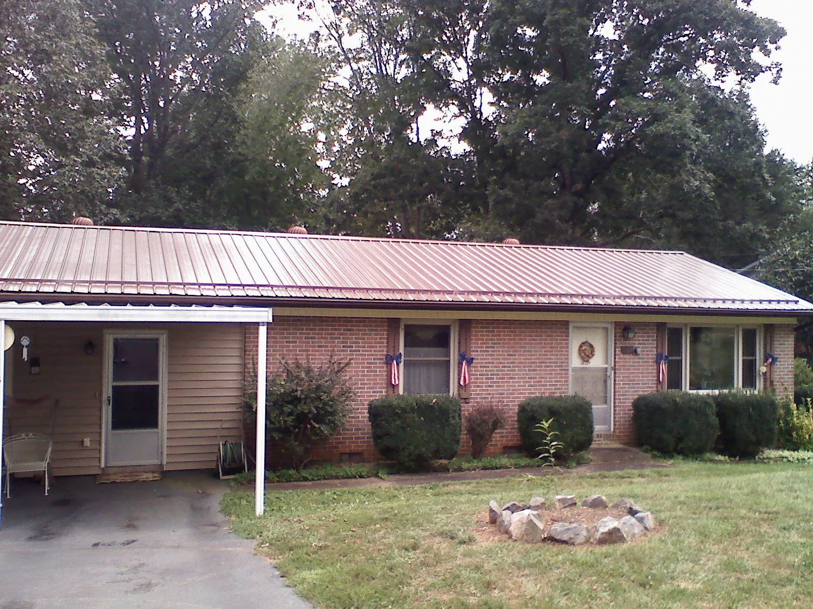 Bronze metal roof and carport on a brick ranch home — Roof Repair work by our crew in Castro Valley